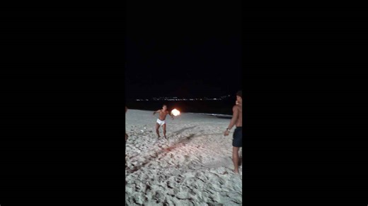 Friends play fiery beach ball game in Niterói, Brazil