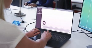 Caucasian woman in office using computers with ai digital messaging on screens. Business, office, communication, connection and technology.