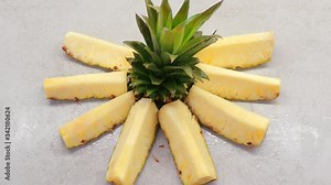 the process of cleaning and slicing fresh pineapple on the kitchen table