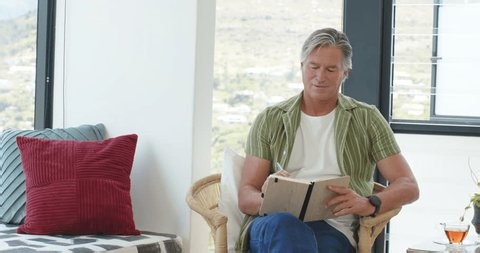 clip-4000938981-mature-man-wicker-chair-near-window-writing