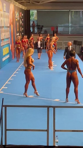 Female Bodybuilders Showcase Physique on Blue Stage