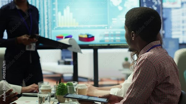 Diverse work team collaborating on project management tasks, utilizing smart technology and detailed analytics to optimize resource allocation and ensure enterprise objectives. Camera A.