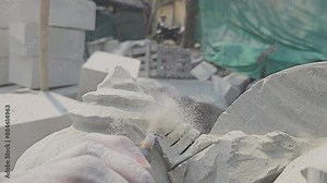 Indian Stone Carving Artists Creating Hindu God Statue Of Stone. Cutting rock with grinder. Stone sculptor creates sculpture on workshop. Young artisan at work sculpture.