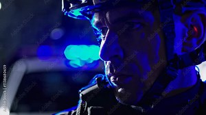 Close-up of SWAT officer in night crime scene. Police cars with flashing lights. Crime scene investigation. Law enforcement in action