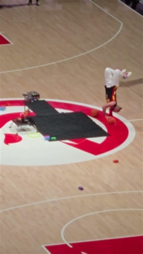 An AGT acrobat is dribbling while upside-down during an NBA Basketball halftime show, Atlanta
