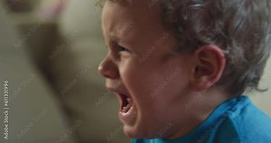 Close Up Portrait of a Little Male Toddler Crying and Screaming at Home. Angry and Frustrated Baby Throwing a Tantrum, Being Upset and Sad, Expressing his Emotions Loudly Stock Video