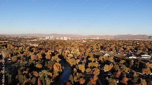 Drone pan left over caughlin ranch valley full of fall color with Reno in the distance.