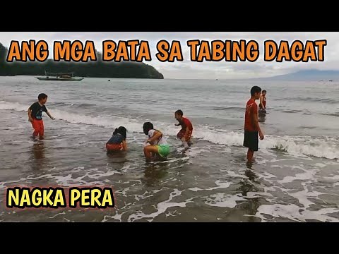 MGA BATANG MASAYANG NALILIGO AT NAGLALARO SA TABING DAGAT
