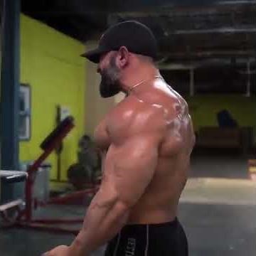 Bearded muscle bull muscle daddy pumping iron at gym in workout short shorts