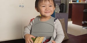 A mom invented a bib that holds kids' snacks — and it even folds over so you can take it on the go