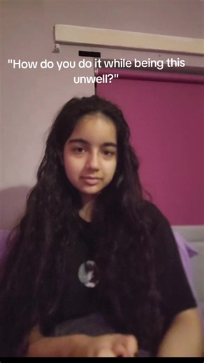 Video description: Zea, a teenage girl eith long dark curly hair and an olive-toned complexion, lip-syncs to Hall of Fame by the script. The on-screen text says: 'How do you do it while being this unwell?' When the audio mentions smiling through difficulty, she points to her mouth and smiles. The video highlights how people with chronic illnesses can still achieve things despite symptoms and setbacks. End of video. #chronicallyill #invisibleillness #spooniewarrior #fyp #relatabl