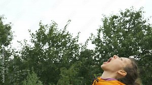 beautiful woman catches raspberry with mouth slow motion