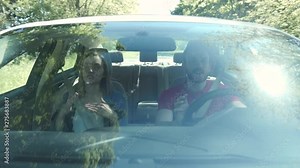 Happy young couple driving car dance sing wheel transport travel passenger vacation fun road journey inside insurance window cheerful freedom friends slow motion