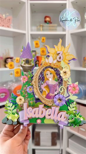 Susie • Party Decor, DIY and Crafting on Instagram: "In love with how this Rapunzel cake topper came out 💜 now I want to make one for all the princesses 😍 I used the perfect combination of pastel colored cardstock from @the_orangepeony & colored foamies from @fancifulchaos Photo paper by @koalagp_paper Satin 72lb photo paper Printed with Canon Pixma"