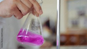 Scientist Mixing Titrant And Analyte In An Erlenmeyer Flask (Conical Flask) By Shaking In An Orbital Motion - Titration Procedure In The Lab - close up