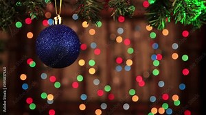 Decoration for the new year - a shiny blue ball close up. The green ray moves along the surface of the toy. Multi-colored holiday lights flicker in the background. Congratulatory Christmas video card. Stock Video