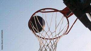 Basketball ball hits into hoop outdoors close-up. successful throw of ball in basketball basket.