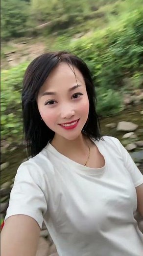 Pretty Chinese woman shows her long tongue on vacation