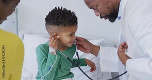 African american male doctor examining child patient, using stethoscope at hospital
