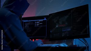 Unrecognizable hacker man typing on keyboard and engaging hacking into security systems