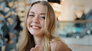 Beautiful Caucasian girl flirting seductive woman showing hey you, come here gesture shows direction in front of her ask join inviting hand welcoming lady looking at camera playful flirtatious indoors