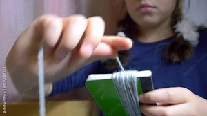 Girls making dolls from strings.