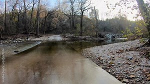 Drive plate Gravel road during Missouri fall over a small creek bridge