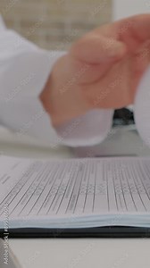 Vertical Screen: Close up female doctor doing paperwork and saving document in laptop in the office. Senior therapist filling medical checklist sitting at the desk. Health care and insurance concept.