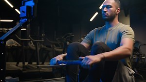 Sport workout in gym exercise with rowing machine simulator sitting dead lift low row in sportive club effort goals motivation health African American man sporty male guy athlete sportsman bodybuilder