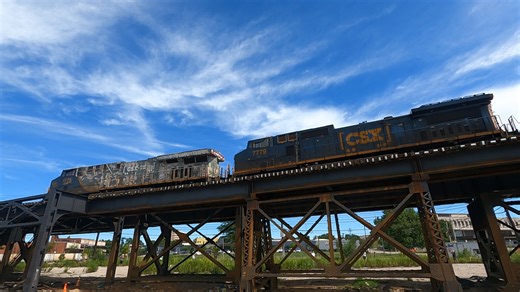 ***THROWBACK VIDEO*** On July 30, 2022, in Cincinnati, Ohio, we observed CSX 1776 (Honoring Our Veterans) leading and CSX 7779 trailing on a westbound-to-northbound manifest train. The train crossed the historic Chesapeake and Ohio Railway bridge, a 1,550-foot cantilever truss structure that spans the Ohio River, connecting Covington, Kentucky, to Cincinnati, Ohio. After crossing the bridge, the train proceeded along an elevated stretch of track, seen in the video, which extends nearly a mile be