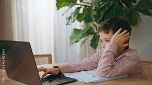 Concentrated child typing laptop studying home closeup. Schoolboy doing homework Stock Video