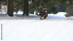 Beautiful girl in black clothes ride on a snowy mountains by the sled. Sledding
