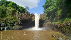 Rainbow Falls stock video. Drone footage flying low over river of iconic waterfall in Hawaii.