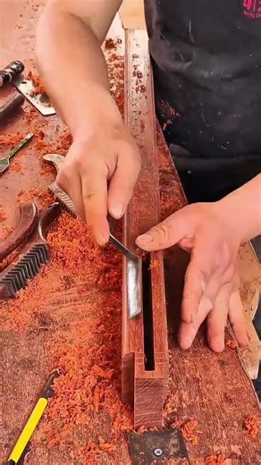 Careful chiseling shaping rectangular groove in wooden piece