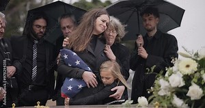 Funeral, family hug and sad people with grief support, goodbye service and mourning death at burial event. Kid child, mom embrace and group gathering together at coffin, casket and crying at ceremony