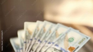 Hands count bills money: they shift dollars, spread out like a fan, flip through bills. One hundred dollars. Stack of $ 100 bills in close-up. Finance, economy, financial planning, economics, savings.