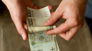 man counts polish money in his hands