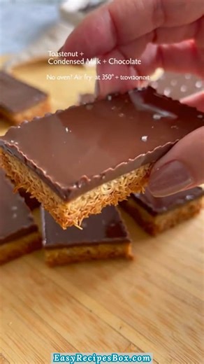 🥥🍫 3-Ingredient Toasted Coconut Mounds Bars 🍫🥥 I make these when I want that classic candy bar vibe with deeper flavor and zero fuss. Toasting the coconut adds warmth and crunch that makes these feel extra special. 🥥 INGREDIENTS: Main Ingredients: - 2 cups shredded coconut - 1/2 cup sweetened condensed milk - 1 cup chocolate chips ... #CoconutBars #NoBakeDessert #HomemadeTreats | Easy Recipes Box