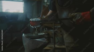 Blacksmith working with hot metal and borax powder in a forge