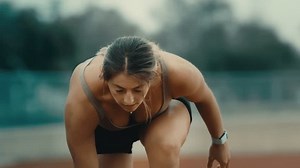 Track runner looking up before race start in extreme slow motion, young female dramatic look up in 4k 800fps