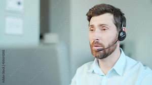 Corporate operator working in customer support service on helpline telesales. Focused man representative call center agent in wireless headset helping client with complaints using computer in office