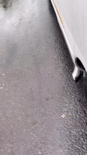 Close-Up of White Vehicle Exhaust on Wet Road