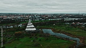 Drone shot of Millennium Tower (Jahrtausendturm) in Elbauen park near Elbe river, Magdeburg city. Cone-shaped structure with a viewing platform & exterior ramp plus science & technology exhibits.