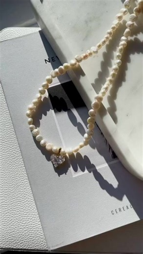 Heart Charm Necklace Joey Baby introduces a masterful blend of contemporary style with this Heart Charm Necklace. It's more than just a piece of jewelry; it's a statement of elegance and modern flair. Match this with the new Lola Earrings to complete the look. Ditching the conventional bling, this heart charm necklace is a beacon of refinement. Each necklace radiates with the luster of exquisite freshwater pearls, carefully selected and intricately handcrafted right in the heart of Manhattan, Ne