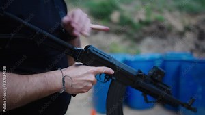 Caucasian male attach magazine with combat bullets on weapon, Olesko, Czechia