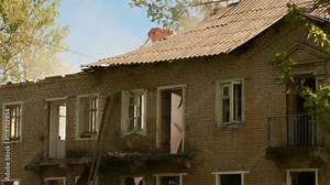 excavator destroys the roof of the building. Demolition old house. excavator destroys old brick two-storey building