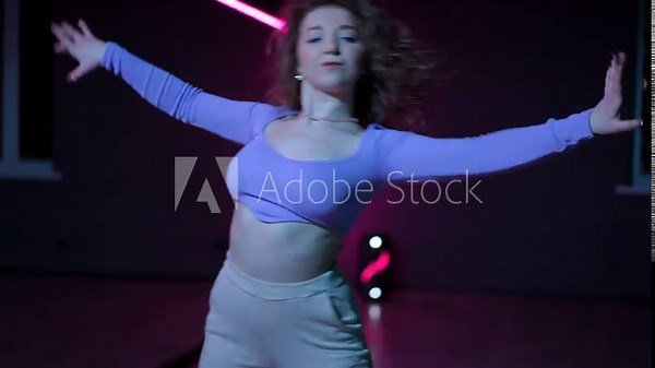 Live camera. A dancer skillfully dances modern dance in a choreographic hall with neon illuminated mirrors