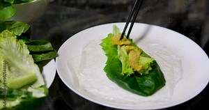 cooking process rice paper wrap salad cucumber and pieces of lard woman's hands on white plate oriental food cooking step by step