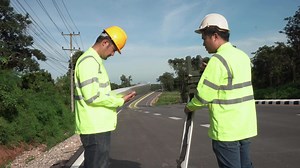 Download Teamwork of surveyor engineers worker making measuring with theodolite on road highway. Survey engineer at road construction site, surveyor equipment. Construction concept. for free