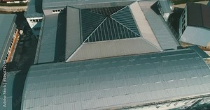 A modern building with a glass roof from a bird's eye view, highlighting its innovative design, impressive architecture, and urban landscape